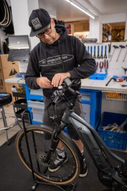 Fahrradmechaniker und Werkstattleiter Benjamin schraubt an Fahrradlenker, Vorbau, E-Bike Display in Fahrradwerkstatt von rodenstein-bikes.